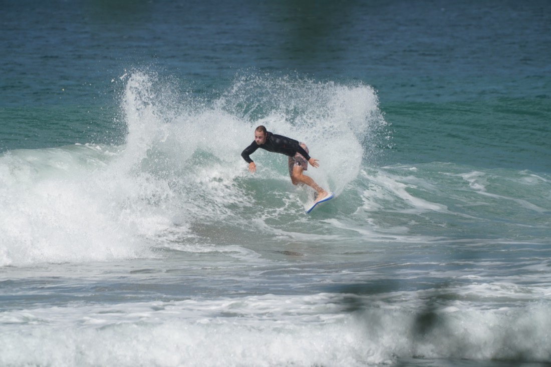 Logan surfeando una ola